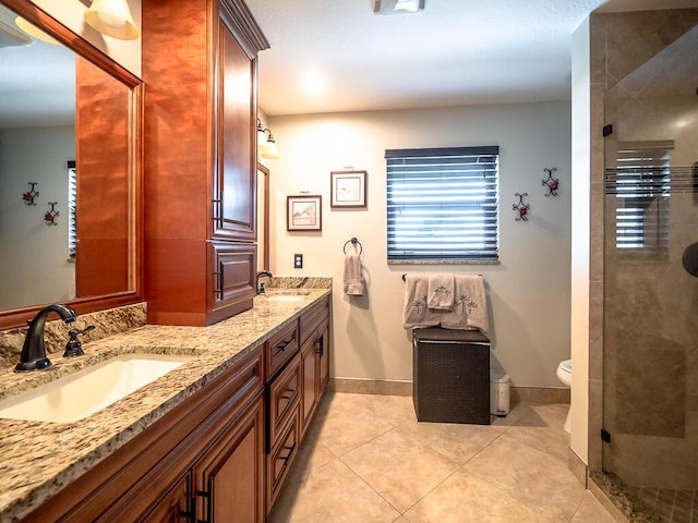 bathroom featuring vanity, tile patterned flooring, toilet, and walk in shower