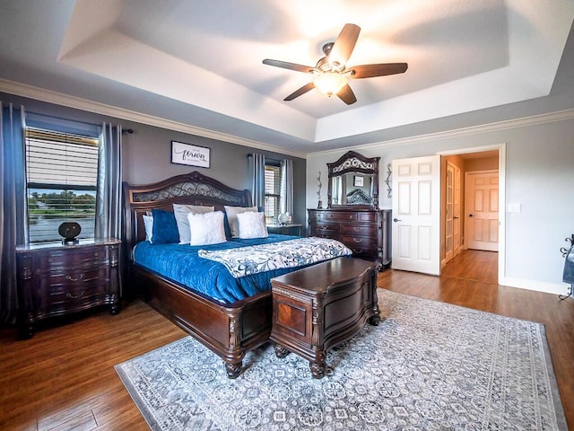 bedroom featuring hardwood / wood-style floors, a tray ceiling, and ceiling fan