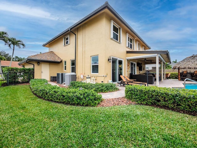 back of property featuring central AC unit, an outdoor living space, a lawn, and a patio