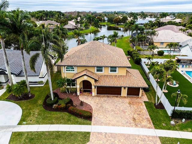 view of front of home with a garage, a water view, and a front yard