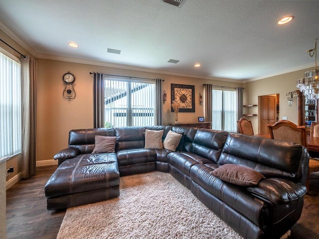 living room featuring a wealth of natural light, ornamental molding, dark hardwood / wood-style floors, and a chandelier