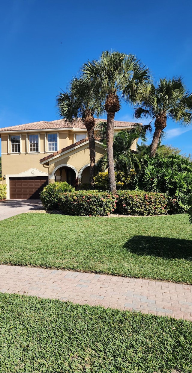 view of front of home with a garage and a front lawn