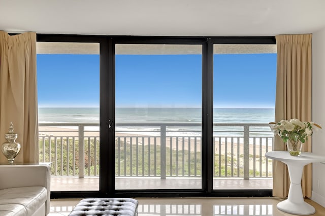 unfurnished living room featuring a view of the beach and a water view