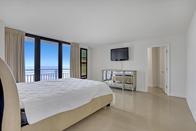 tiled bedroom featuring access to exterior and a wall of windows