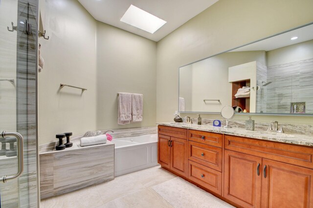 bathroom with separate shower and tub, vanity, and a skylight