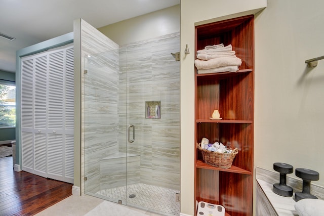 bathroom featuring hardwood / wood-style flooring and a shower with door