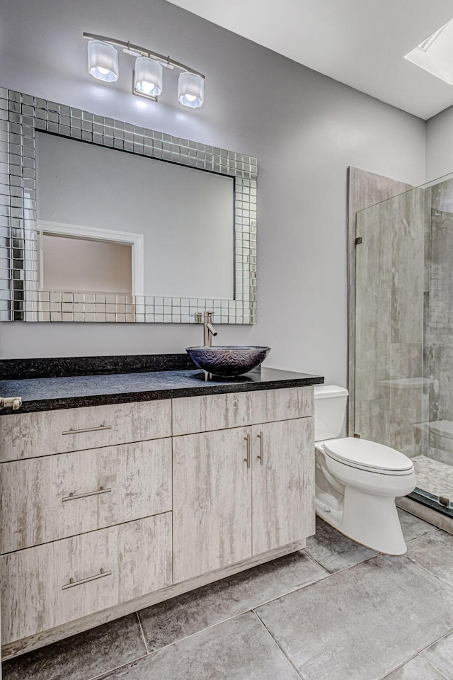 bathroom with vanity, toilet, and a tile shower