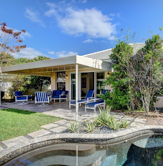 back of property with outdoor lounge area, a pergola, and a patio area