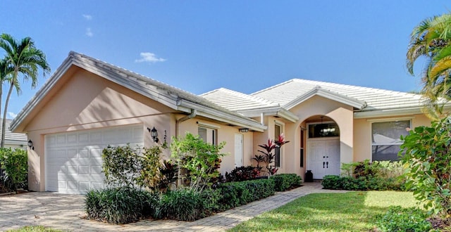 ranch-style home featuring a garage and a front yard