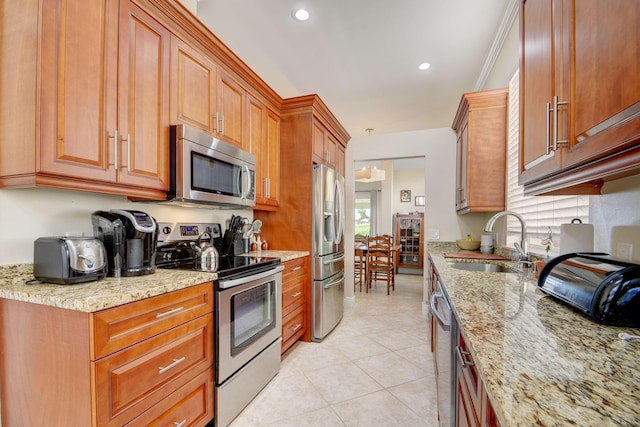 kitchen with stainless steel appliances, light tile patterned flooring, sink, and light stone counters