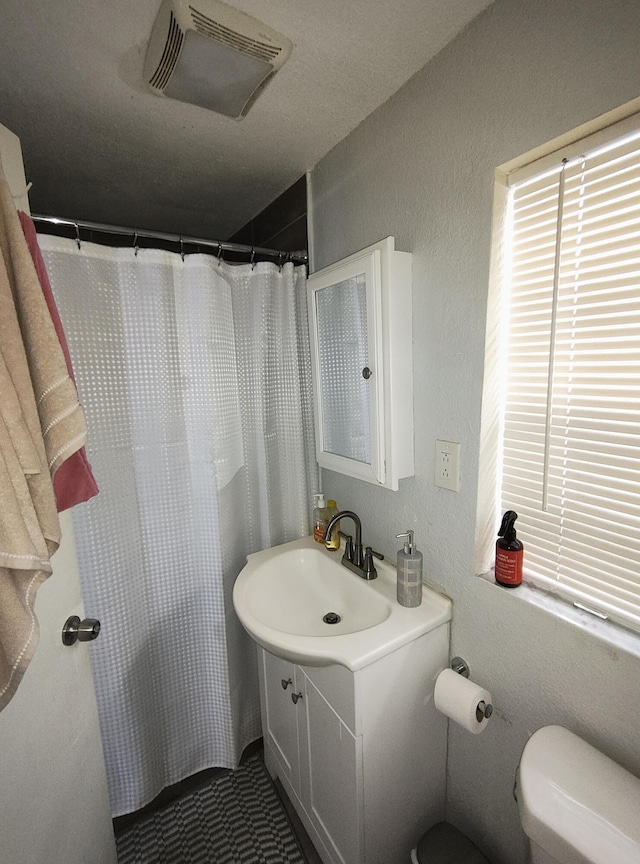 bathroom with vanity, walk in shower, and toilet