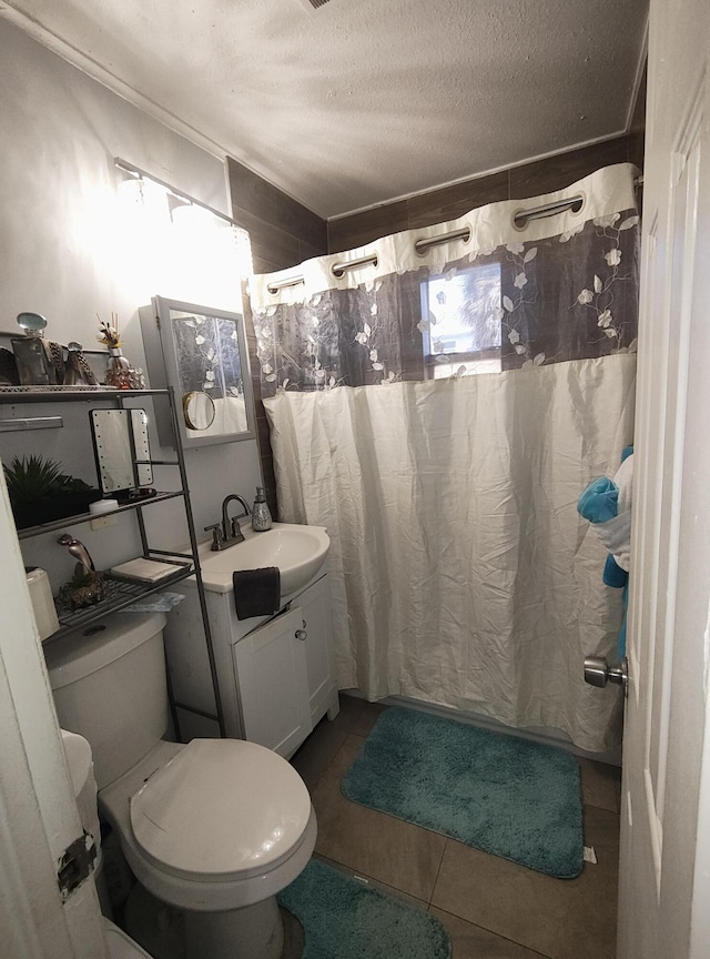 bathroom with walk in shower, tile patterned floors, toilet, a textured ceiling, and vanity