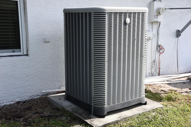 exterior details with electric meter, central AC, and stucco siding