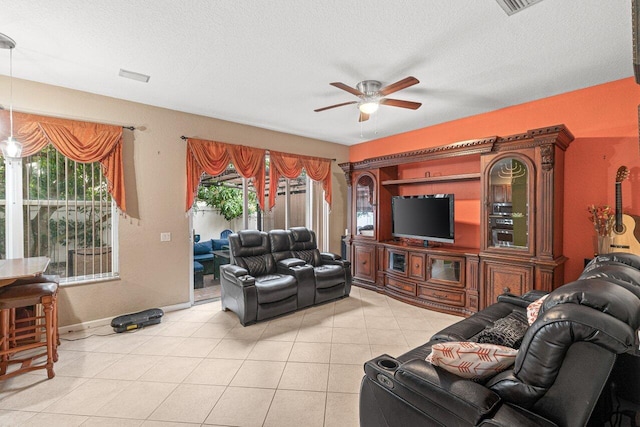 tiled living room with ceiling fan and a textured ceiling