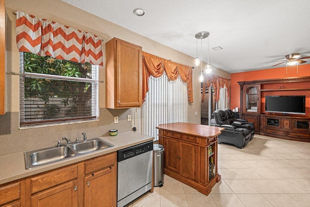 kitchen featuring light tile patterned flooring, sink, hanging light fixtures, stainless steel dishwasher, and a textured ceiling