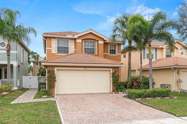 mediterranean / spanish-style home with a garage and a front lawn