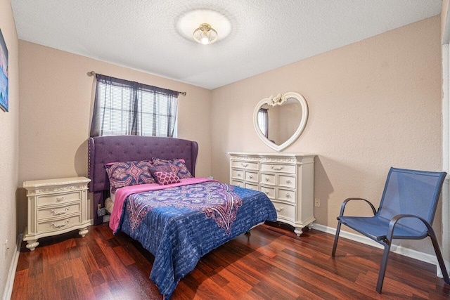 bedroom with dark hardwood / wood-style flooring and a textured ceiling