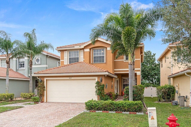 mediterranean / spanish house with a garage and a front yard