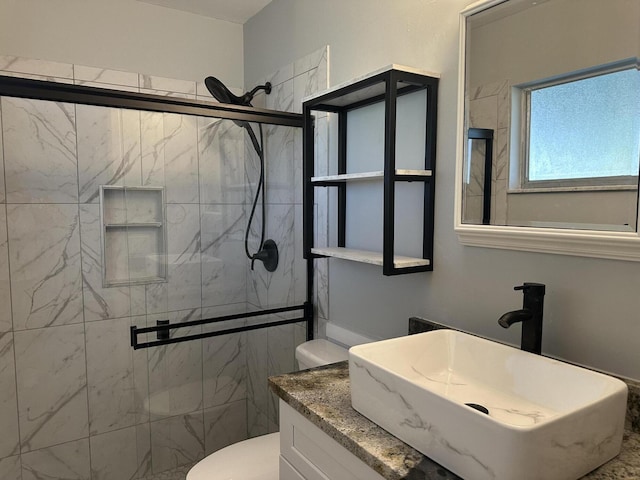 bathroom featuring toilet, an enclosed shower, and sink