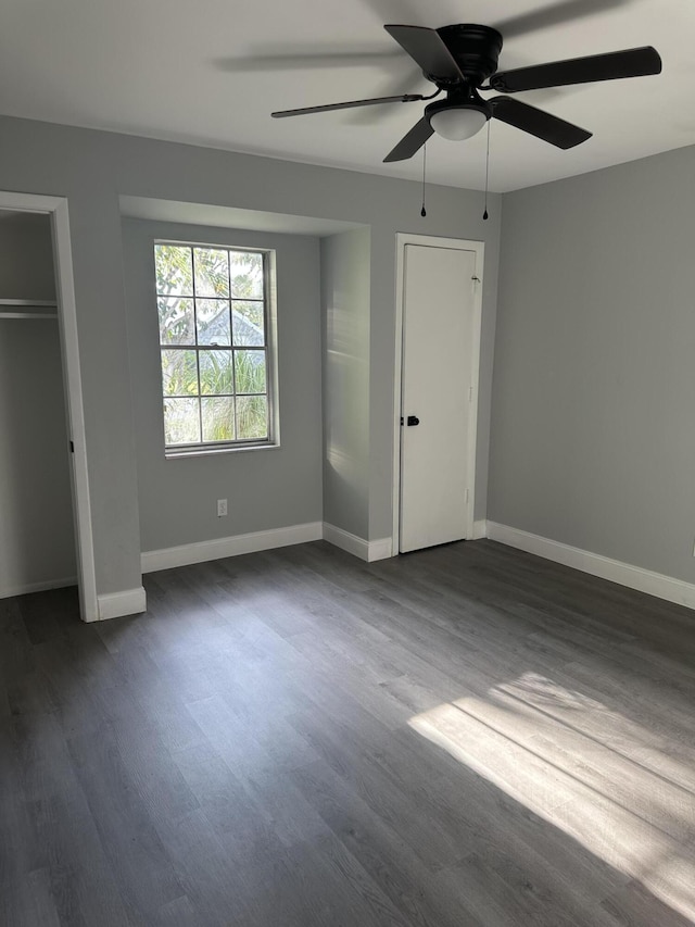 unfurnished bedroom featuring ceiling fan and dark hardwood / wood-style floors