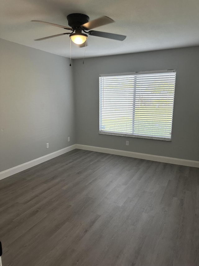 spare room with dark hardwood / wood-style flooring and ceiling fan