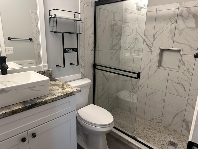 bathroom with an enclosed shower, vanity, wood-type flooring, and toilet