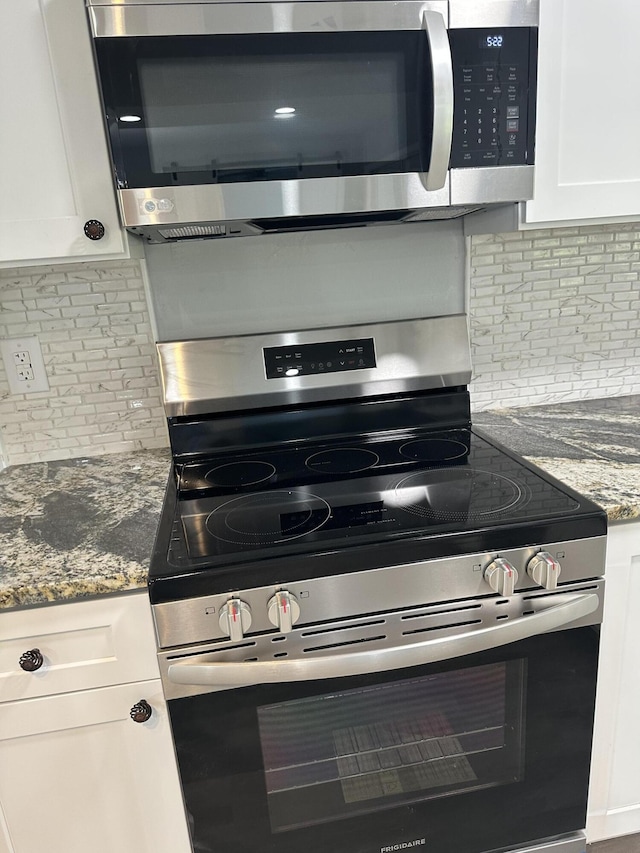 kitchen with stainless steel appliances, white cabinetry, and tasteful backsplash