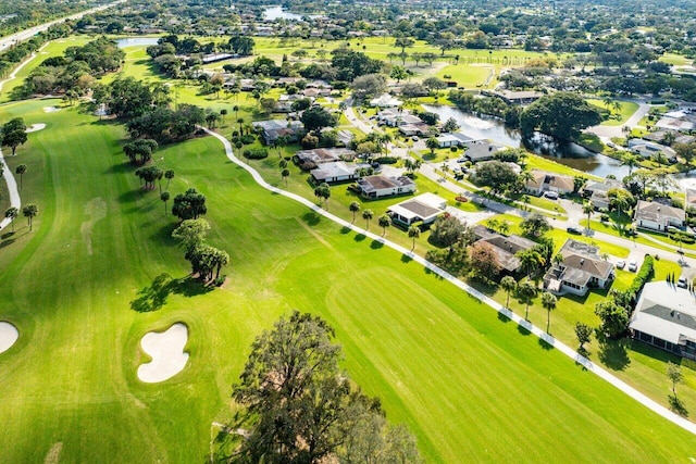 drone / aerial view featuring a residential view, view of golf course, and a water view