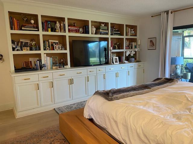 bedroom featuring light wood-style flooring and crown molding