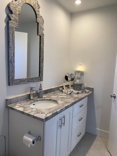 bathroom featuring tile patterned flooring, baseboards, and vanity