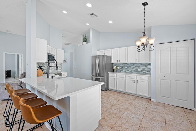 kitchen featuring high vaulted ceiling, backsplash, pendant lighting, stainless steel appliances, and white cabinets