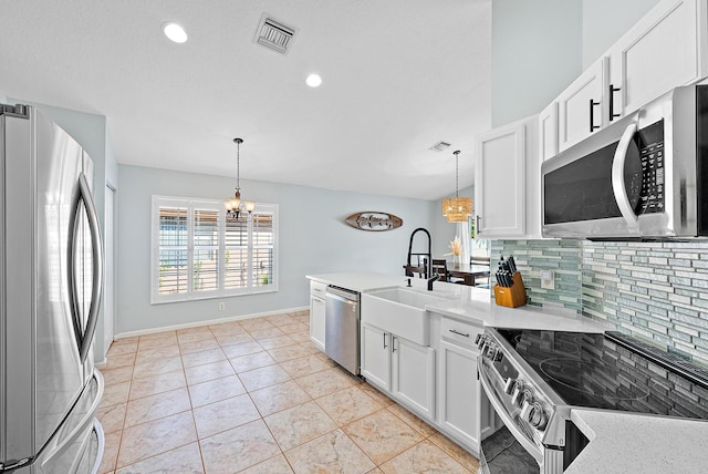 kitchen featuring tasteful backsplash, appliances with stainless steel finishes, white cabinets, and a notable chandelier