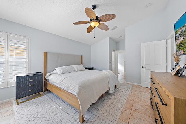 bedroom featuring light tile patterned flooring, vaulted ceiling, a textured ceiling, and ceiling fan