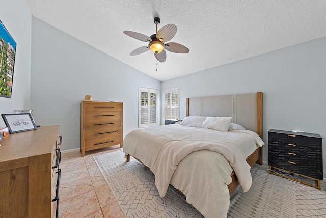 tiled bedroom featuring a textured ceiling, vaulted ceiling, and ceiling fan