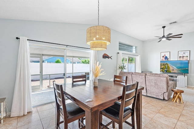 tiled dining area with ceiling fan with notable chandelier