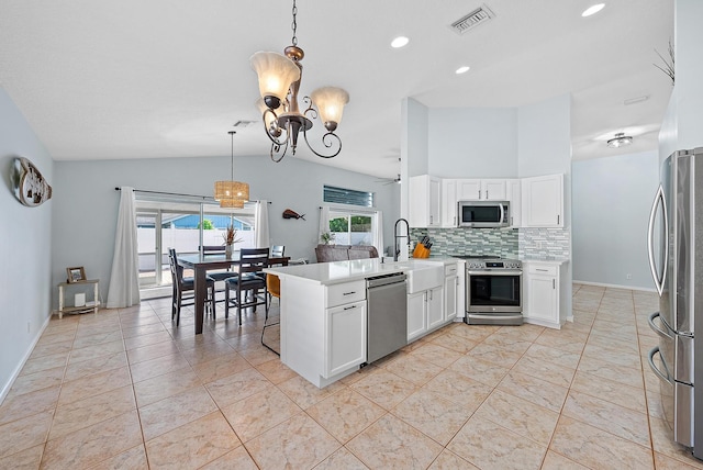 kitchen featuring vaulted ceiling, appliances with stainless steel finishes, tasteful backsplash, hanging light fixtures, and kitchen peninsula