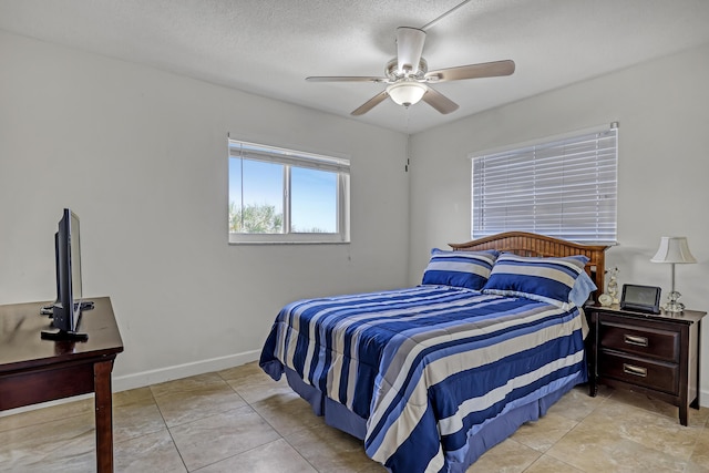 tiled bedroom featuring ceiling fan and a textured ceiling