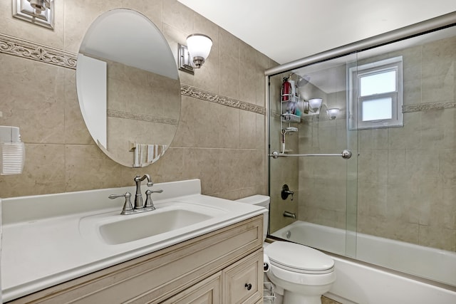 full bathroom with enclosed tub / shower combo, tile walls, vanity, and toilet