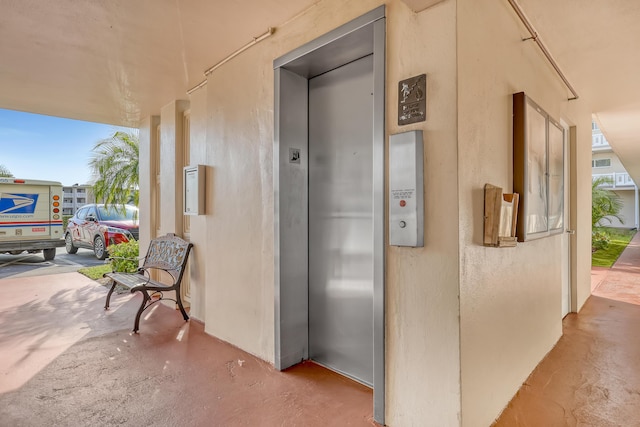 hallway with concrete flooring and elevator