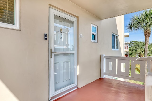 view of exterior entry featuring a balcony