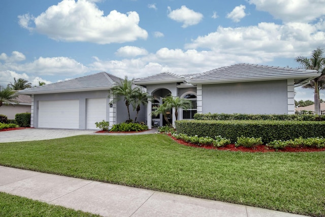 view of front facade with a front lawn, a tile roof, stucco siding, decorative driveway, and an attached garage