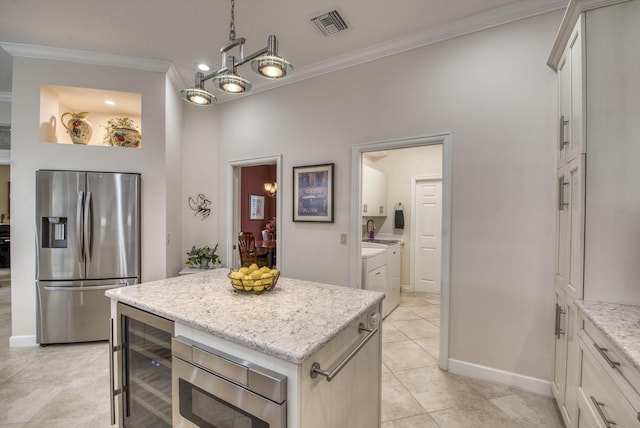 kitchen with light stone countertops, visible vents, ornamental molding, wine cooler, and appliances with stainless steel finishes