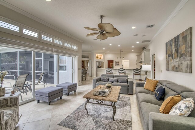 living room featuring ornamental molding, light tile patterned floors, and ceiling fan