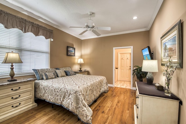 bedroom with ornamental molding, ceiling fan, baseboards, and wood finished floors