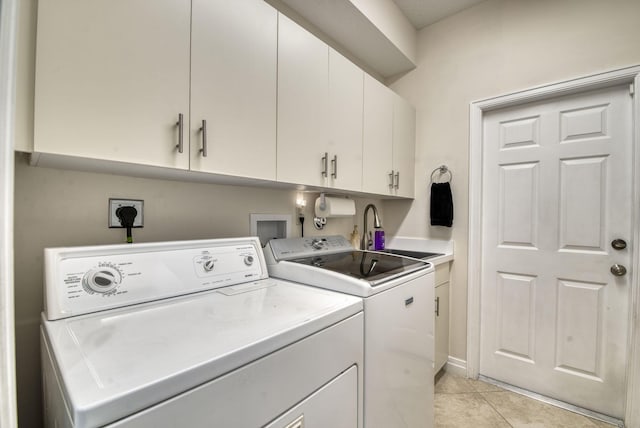 washroom with light tile patterned floors, sink, cabinets, and washing machine and clothes dryer