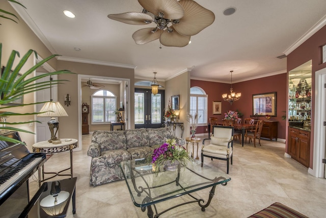 living area with light tile patterned flooring, ceiling fan with notable chandelier, baseboards, and ornamental molding