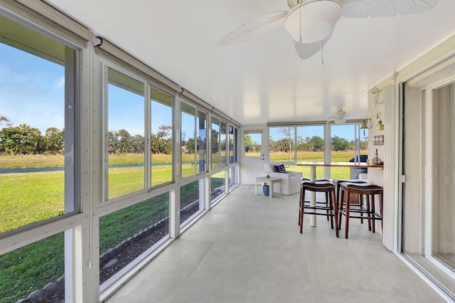 sunroom featuring ceiling fan and a healthy amount of sunlight