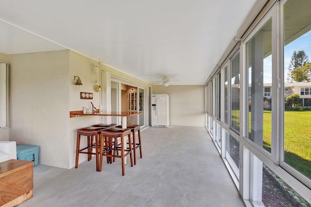 sunroom / solarium featuring ceiling fan