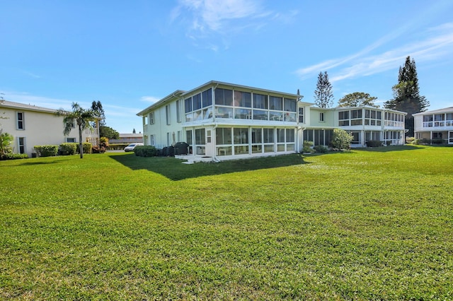 back of property featuring a lawn and a sunroom