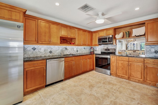 kitchen with sink, ornamental molding, appliances with stainless steel finishes, dark stone counters, and decorative backsplash